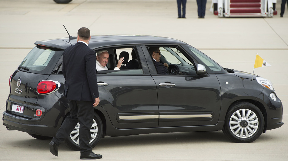 Pope Francis waves from his car, a Fiat, upon arrival at Andrews Air Force Base in Maryland, September 22, 2015, on the start of a 3-day trip to Washington. AFP PHOTO / SAUL LOEB (Photo credit should read SAUL LOEB/AFP/Getty Images)